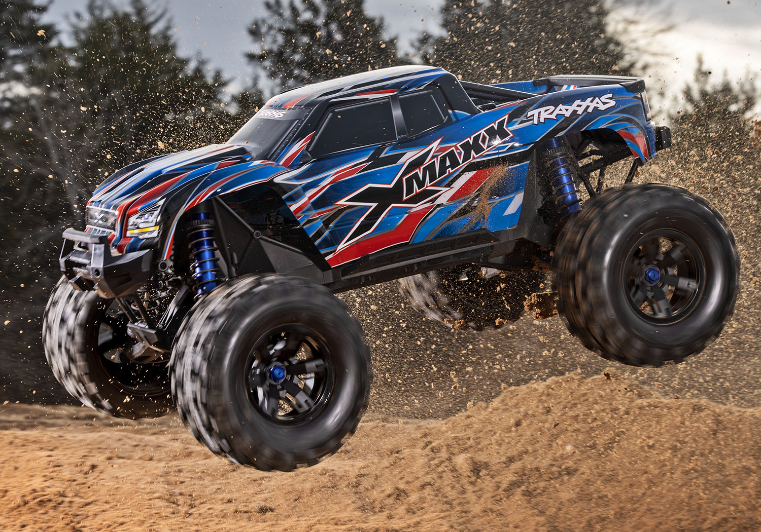 An action shot of the X-Maxx 8S with Belted Sledgehammer Tires (Blue) (TRA77096-4-BLUE).