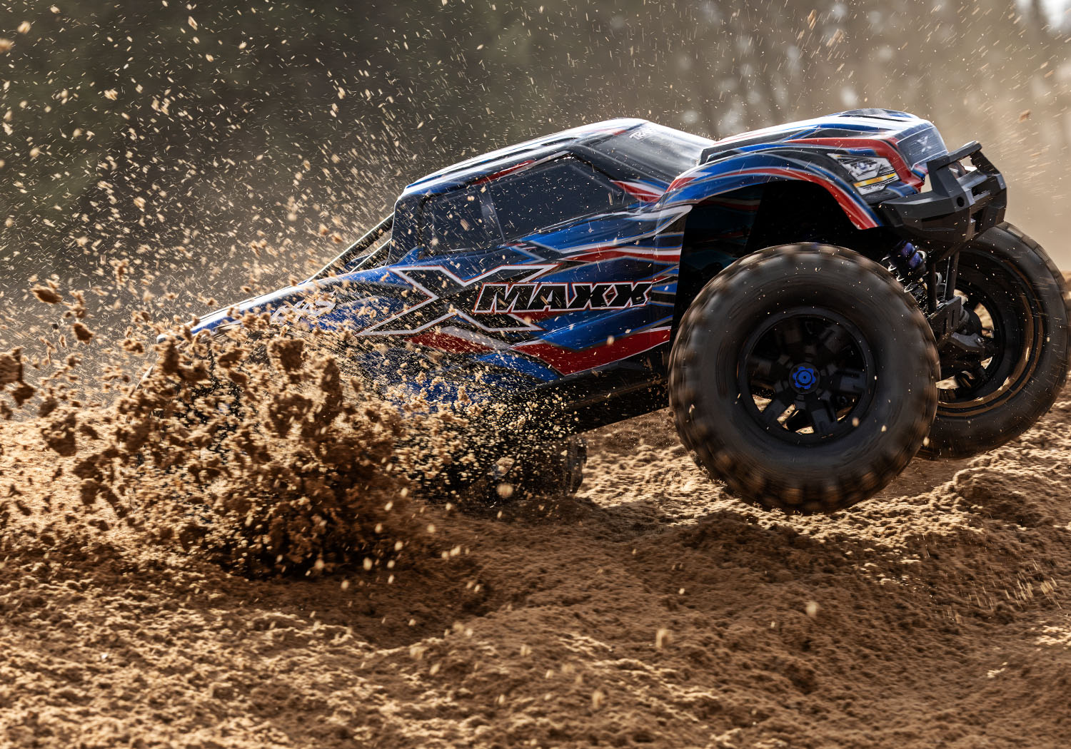 An action shot of the X-Maxx 8S with Belted Sledgehammer Tires (Blue) (TRA77096-4-BLUE).