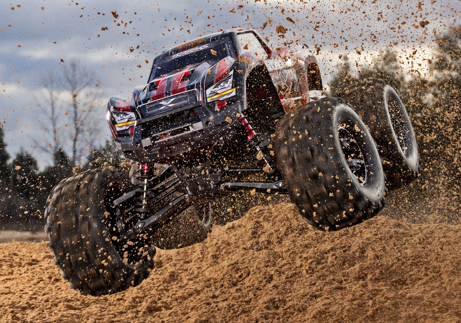 An action shot of the X-Maxx 8S with Belted Sledgehammer Tires (Blue) (TRA77096-4-BLUE).