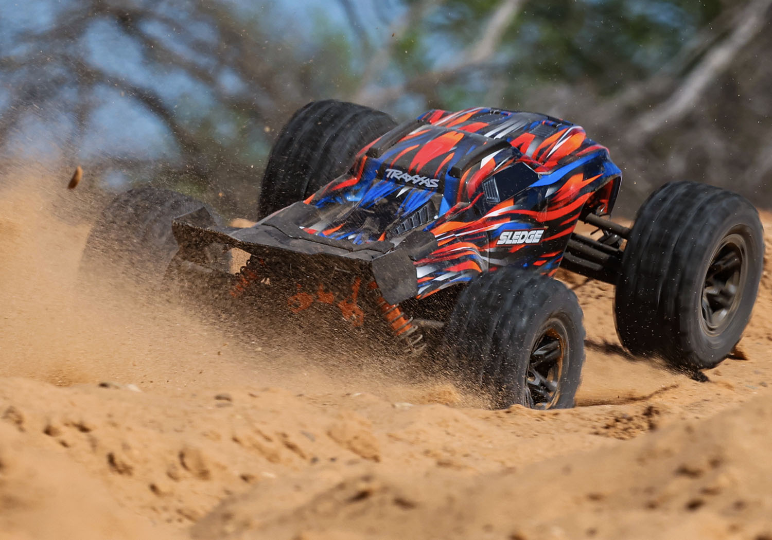 An action shot of the 1/8 Sledge with Belted Sledgehammer Tires Ready to Run (Orange) (TRA95096-4-ORNG).